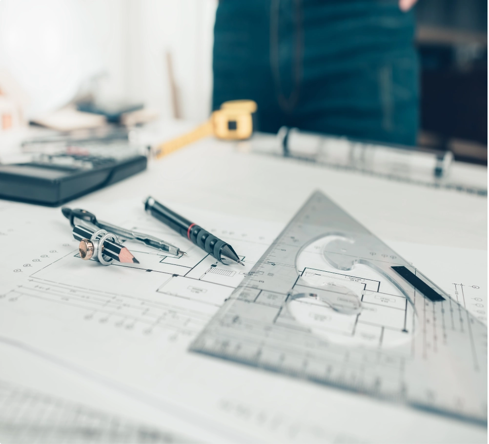 Civil engineer's desk – protractors, pens, compasses, and sketch paper on a desk.